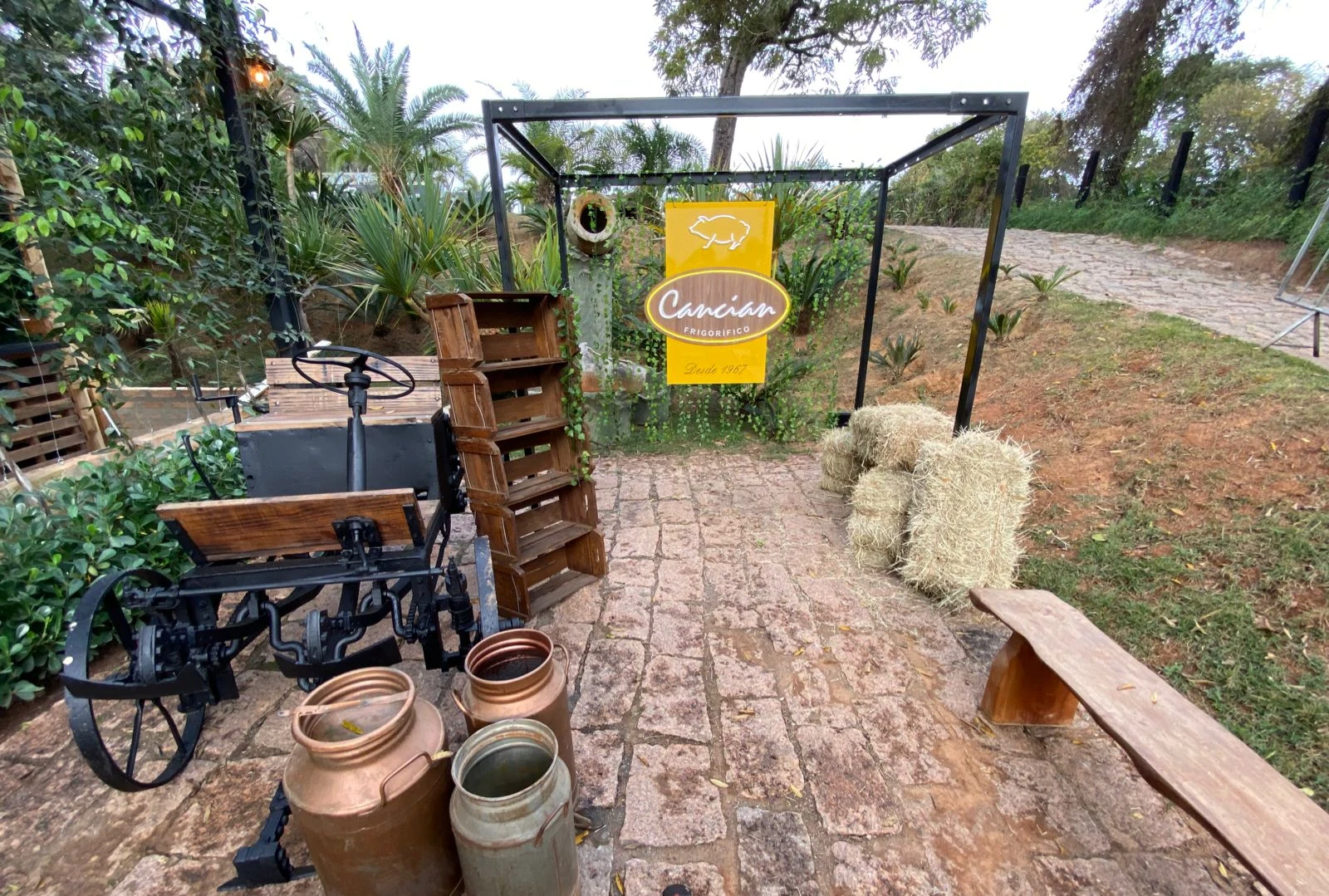 Placa Cancian Frigorífico produzida pela MRC Artes, instalada em ambiente com vegetação.